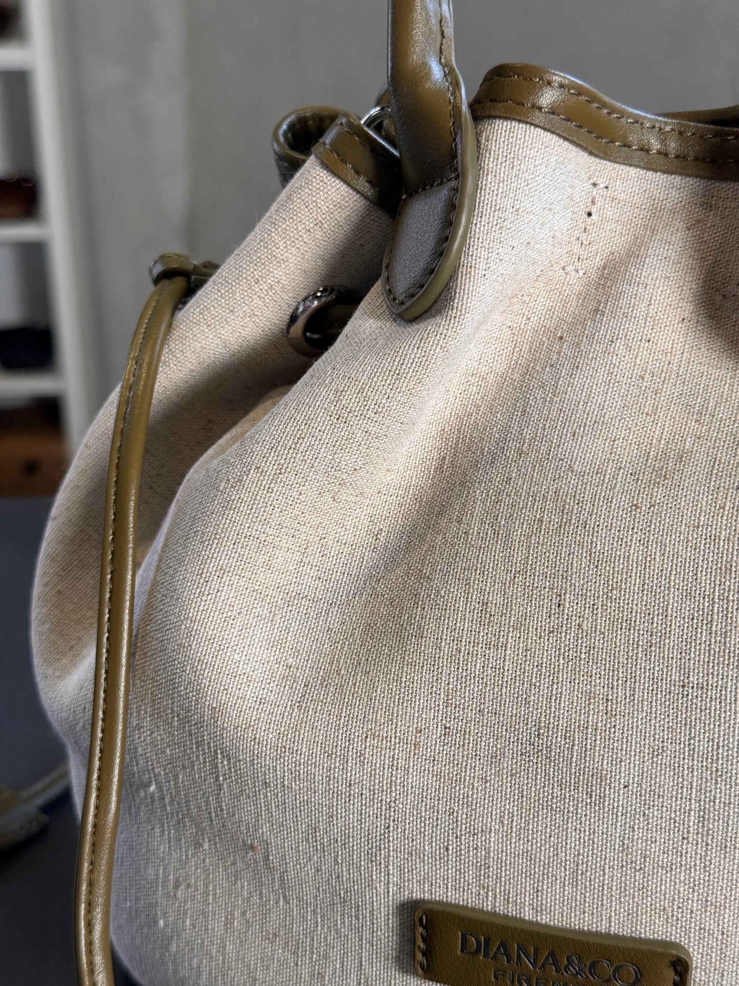 Secchiello in tela beige con profili in similpelle verde oliva con tracolla all’interno 2572